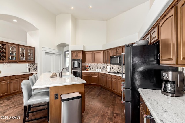 2058 E Marlene Dr, Gilbert, AZ 85296 - kitchen with arched walkways, black microwave, stainless steel double oven, gas stovetop, and backsplash