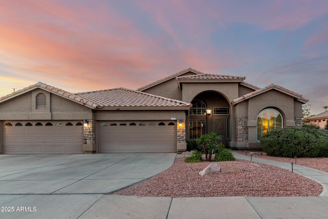 2058 E Marlene Dr, Gilbert, AZ 85296 - mediterranean / spanish-style home featuring a garage, stucco siding, driveway, stone siding, and a tile roof