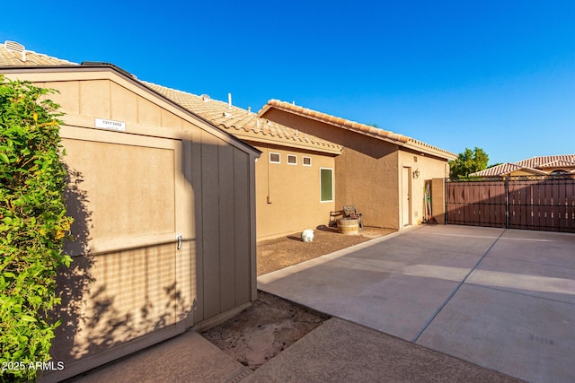 2058 E Marlene Dr, Gilbert, AZ 85296 - view of home's exterior featuring a tiled roof, a storage unit, a patio area, and stucco siding