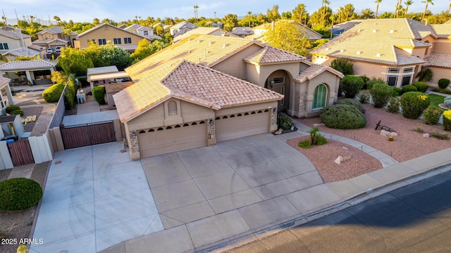 2058 E Marlene Dr, Gilbert, AZ 85296 - mediterranean / spanish-style house featuring a gate, an attached garage, stucco siding, a residential view, and concrete driveway