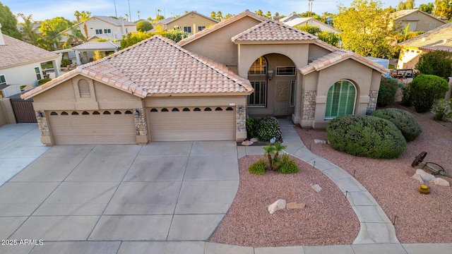 2058 E Marlene Dr, Gilbert, AZ 85296 - mediterranean / spanish home with concrete driveway, a tile roof, stucco siding, a garage, and stone siding