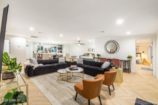 living room with ceiling fan and light parquet flooring