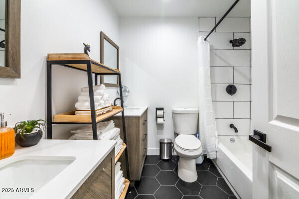 full bathroom featuring tile patterned floors, shower / bath combo with shower curtain, vanity, and toilet