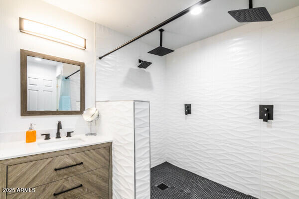 bathroom with vanity and tiled shower