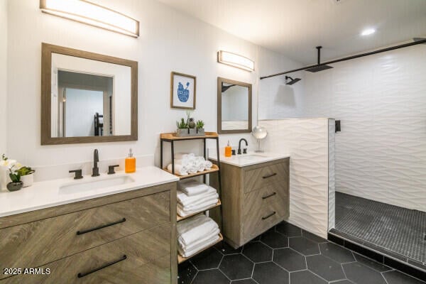 bathroom with tile patterned flooring, vanity, and walk in shower