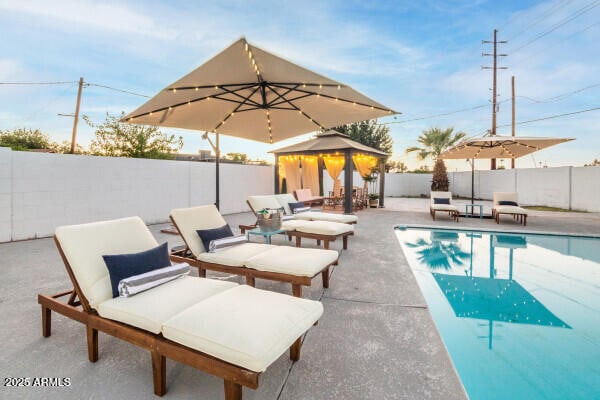 view of swimming pool with a gazebo and a patio area