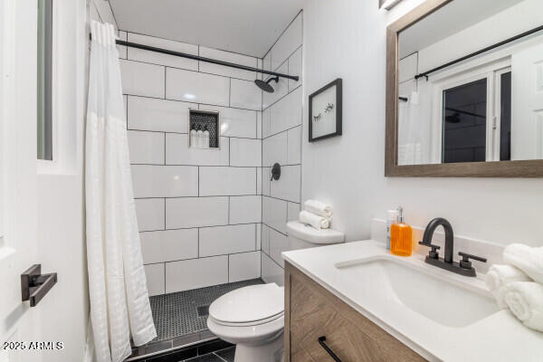 bathroom featuring tile patterned floors, a shower with curtain, vanity, and toilet