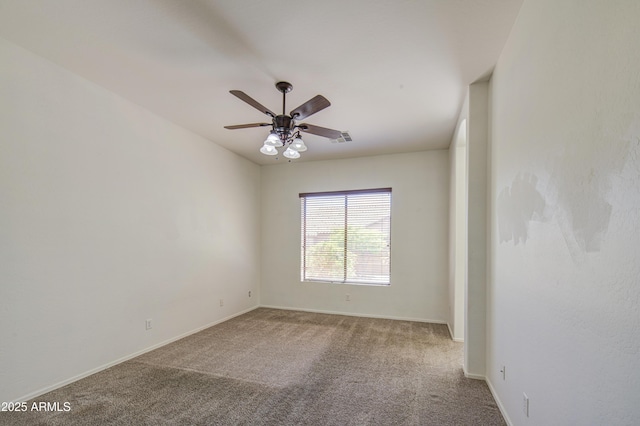 spare room with carpet flooring, ceiling fan, visible vents, and baseboards