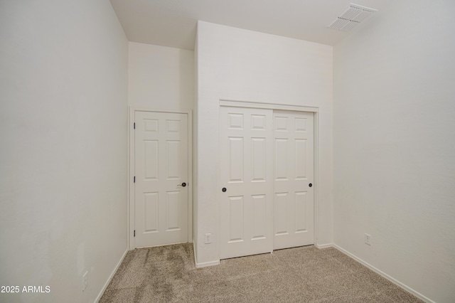 unfurnished bedroom featuring a closet, baseboards, carpet flooring, and visible vents