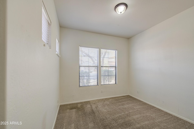 carpeted spare room featuring baseboards