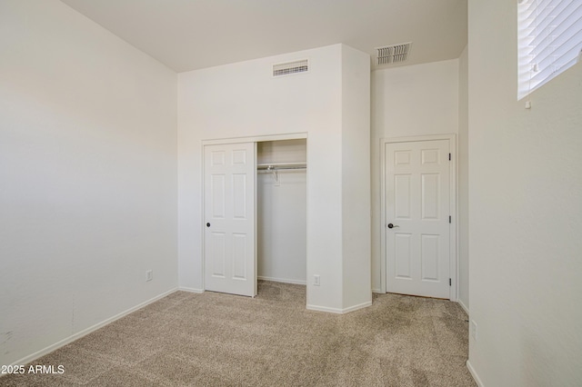 unfurnished bedroom featuring carpet flooring, baseboards, visible vents, and a closet