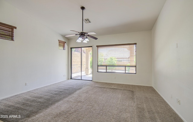 carpeted spare room featuring plenty of natural light, baseboards, ceiling fan, and visible vents