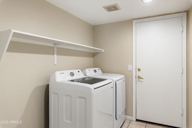 laundry room with laundry area, visible vents, washer and clothes dryer, and light tile patterned flooring