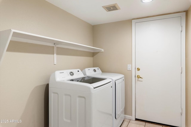 laundry room with laundry area, washing machine and dryer, light tile patterned floors, and visible vents