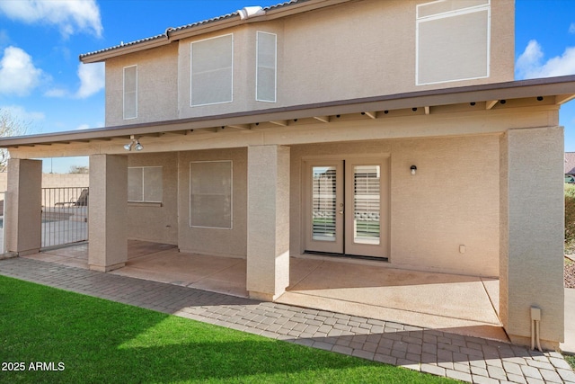 back of house featuring a tiled roof, a patio area, fence, and stucco siding