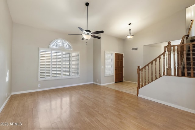 unfurnished room featuring baseboards, stairs, visible vents, and wood finished floors