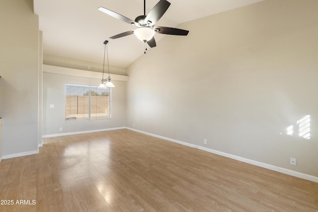 spare room featuring lofted ceiling, light wood finished floors, ceiling fan, and baseboards