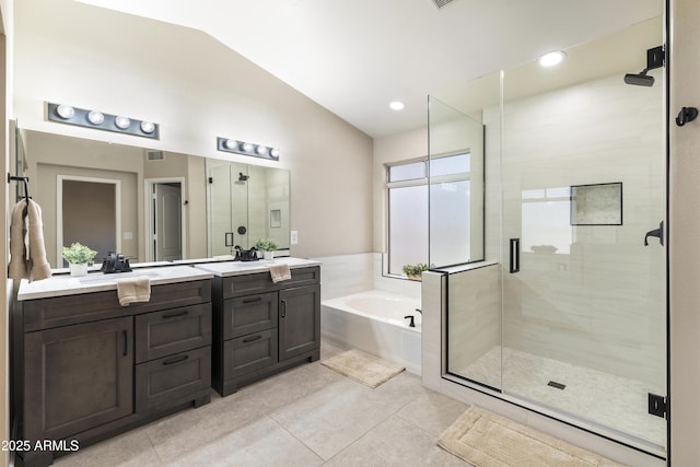 bathroom featuring a stall shower, lofted ceiling, a garden tub, and vanity