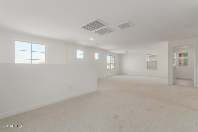 carpeted spare room featuring a healthy amount of sunlight