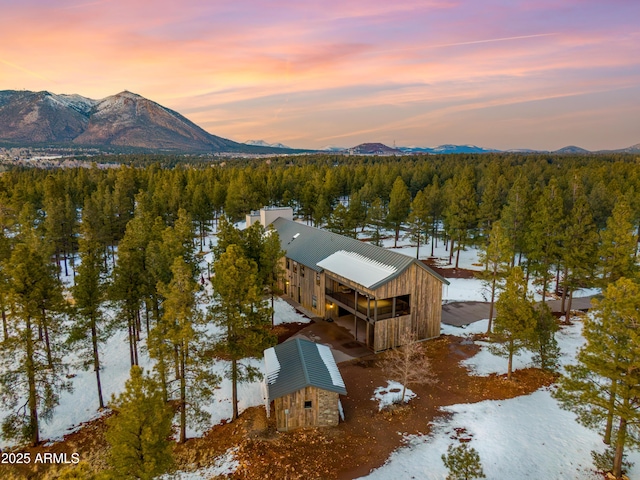 aerial view at dusk with a mountain view and a wooded view