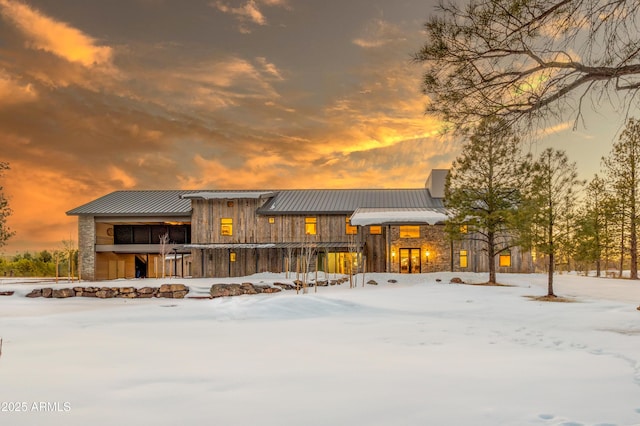 view of front of home with stone siding, metal roof, and a standing seam roof