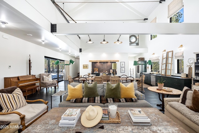 living area featuring beam ceiling, high vaulted ceiling, and wood finished floors