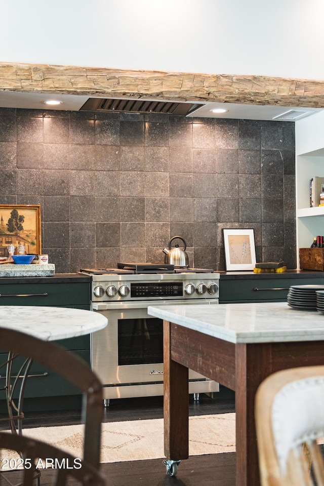 kitchen with stainless steel gas range oven and decorative backsplash