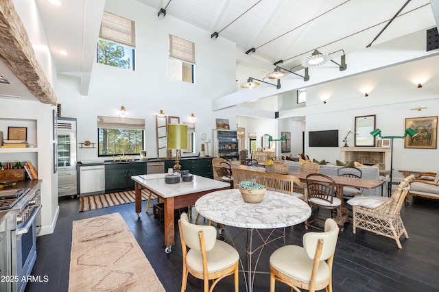 dining space featuring a wealth of natural light, beamed ceiling, high vaulted ceiling, and dark wood finished floors