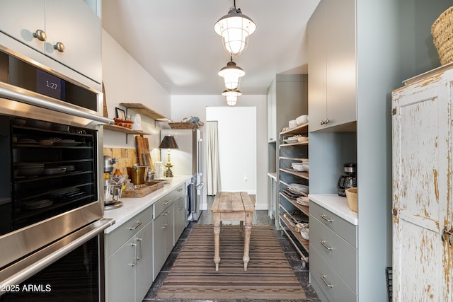 kitchen with open shelves, stainless steel oven, and gray cabinets