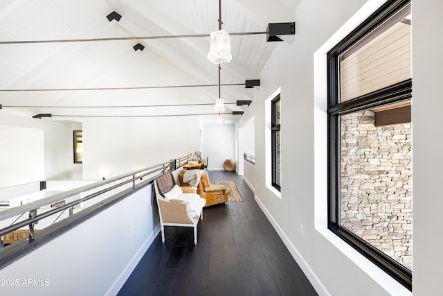 hall featuring beam ceiling, baseboards, wood-type flooring, and high vaulted ceiling