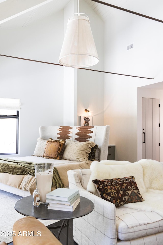 living area featuring visible vents and high vaulted ceiling