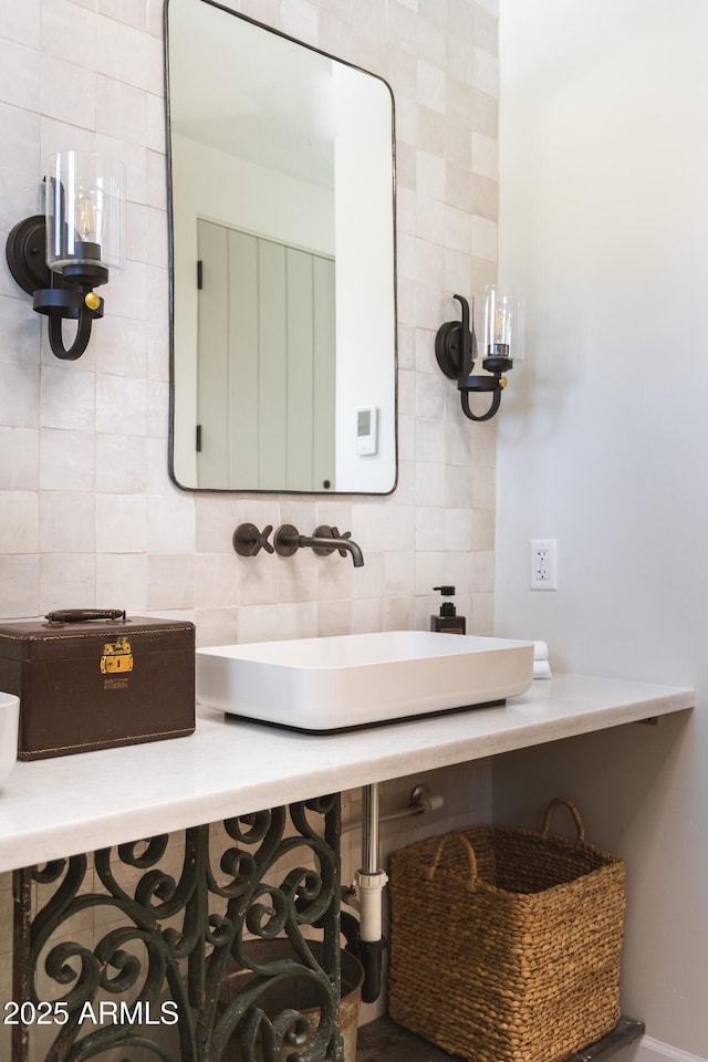 bathroom featuring tile walls, backsplash, and a sink