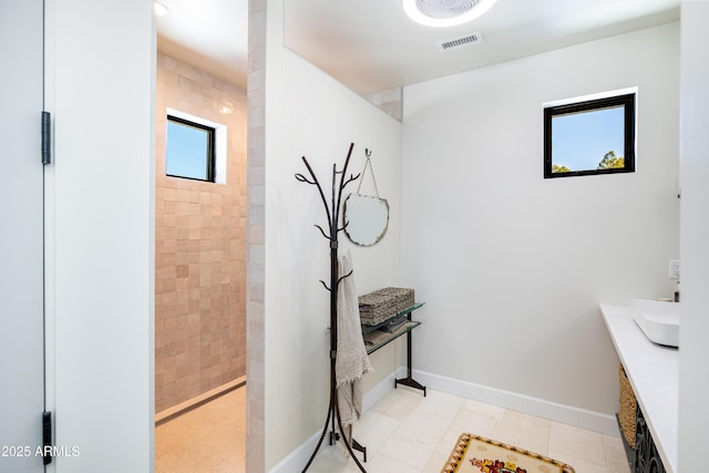 full bathroom featuring tile patterned floors, baseboards, visible vents, and walk in shower