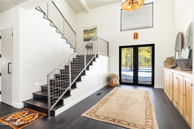 entryway featuring beam ceiling, wood finished floors, baseboards, and french doors