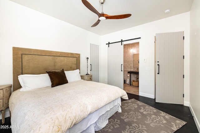 bedroom with a ceiling fan, baseboards, dark wood finished floors, vaulted ceiling, and a barn door