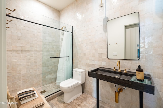 full bath with tasteful backsplash, tiled shower, toilet, and tile walls