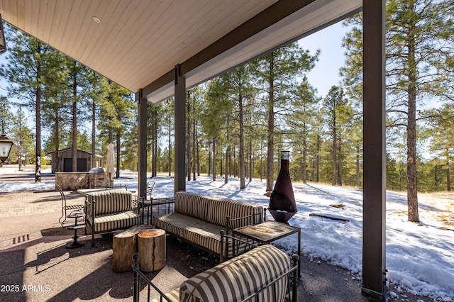 snow covered patio with an outbuilding and an outdoor living space