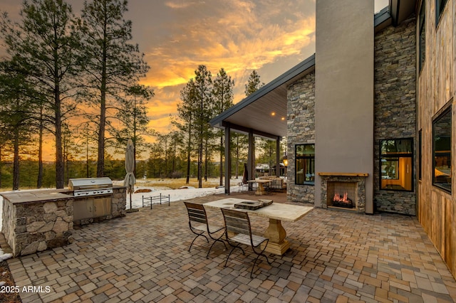 view of patio / terrace featuring an outdoor kitchen, area for grilling, and an outdoor stone fireplace