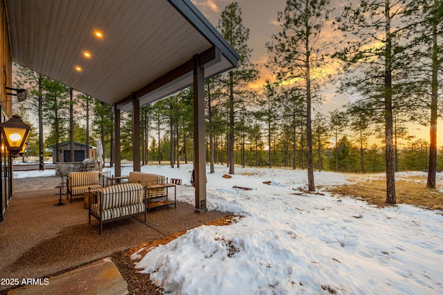 snow covered patio featuring outdoor lounge area