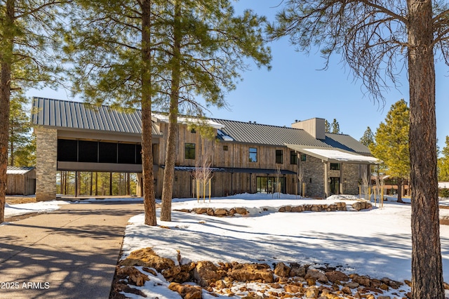 view of front of property with a chimney and metal roof