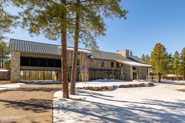 view of front facade with a chimney and metal roof