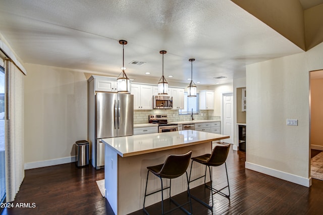 kitchen featuring appliances with stainless steel finishes, a center island, dark wood-type flooring, and a healthy amount of sunlight