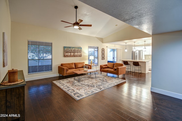 living room featuring a textured ceiling, dark hardwood / wood-style flooring, ceiling fan, and lofted ceiling