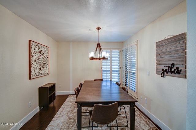 dining space with dark hardwood / wood-style flooring and an inviting chandelier