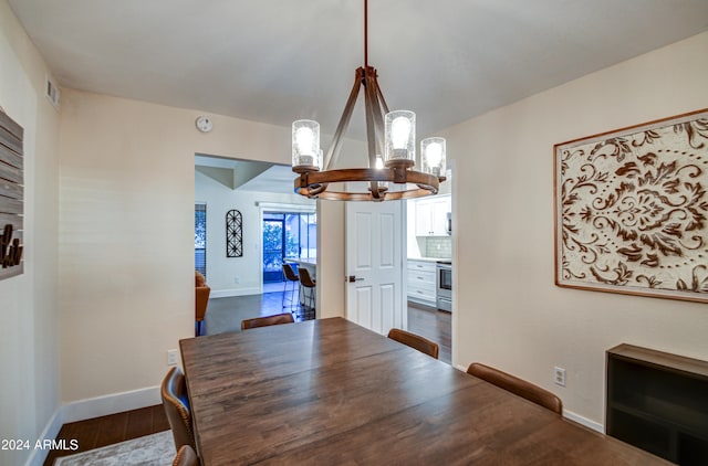 dining area with a chandelier and dark wood-type flooring