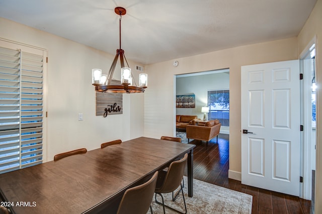 dining area with dark hardwood / wood-style flooring and a notable chandelier