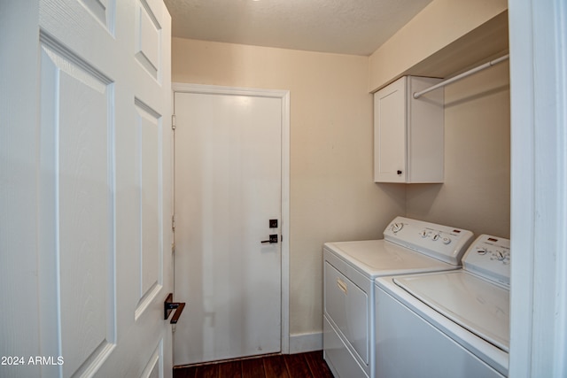 washroom featuring dark hardwood / wood-style floors, cabinets, and washer and dryer