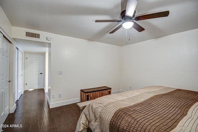 bedroom with a closet, dark hardwood / wood-style floors, and ceiling fan