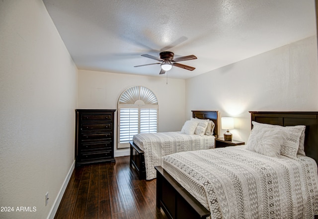 bedroom featuring ceiling fan, dark wood-type flooring, and a textured ceiling