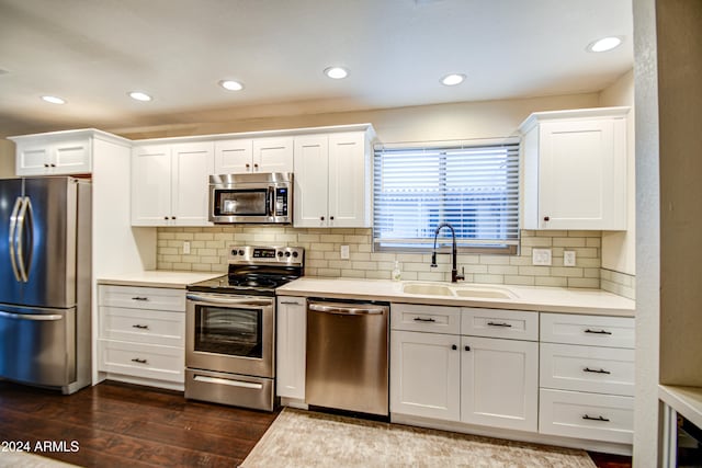 kitchen with white cabinetry, sink, stainless steel appliances, dark hardwood / wood-style flooring, and decorative backsplash